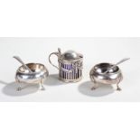 Two silver salts with spoons, the salts with three legs with shell shoulders and hoof feet,