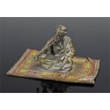 Austrian cold painted brass figure, seated on a carpet a gentleman smoking, 9cm wide