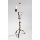 18th Century iron candlestick, the adjustable stand with a long shaft above arched supports, 56cm