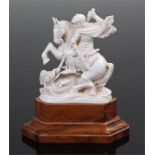 Indian ivory group, carved as St George and the Dragon, raised on a hardwood base, 19th Century /