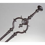 Pair of George III steel fire tongs, the swirl finial above a turned handle and a pair of turned