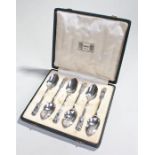 Set of six matched Liberty & Co silver cased spoons, with stylised tulips to the end above a