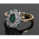 18 carat gold emerald and diamond ring, the central oval emerald with a diamond surround and outer