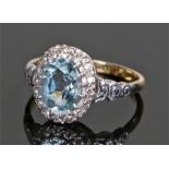 18 carat gold aquamarine and diamond ring, the oval aquamarine with diamond surround, ring size M