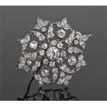 Diamond set flower brooch, the brooch with a central round cut diamond with foliate surround set