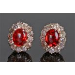 Pair of fire opal and diamond earrings, the oval fire opal with diamond surround, 13mm high