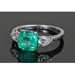 Columbian emerald and diamond set ring, the central emerald at 2.22 carat flanked by diamonds set on