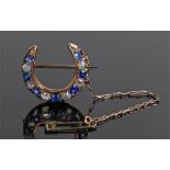 Diamond and sapphire crescent brooch, set with a row of round cut diamonds and sapphires to the