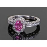 18 carat white gold, diamond and ruby ring, the central oval ruby ring with a diamond surround and