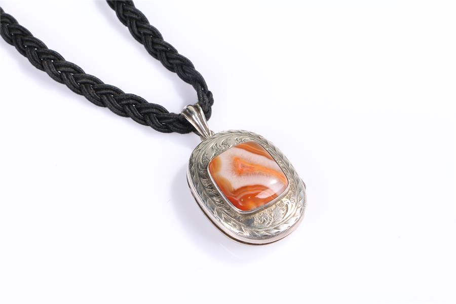 Silver and agate pendent, with a central orange agate with foliate surround