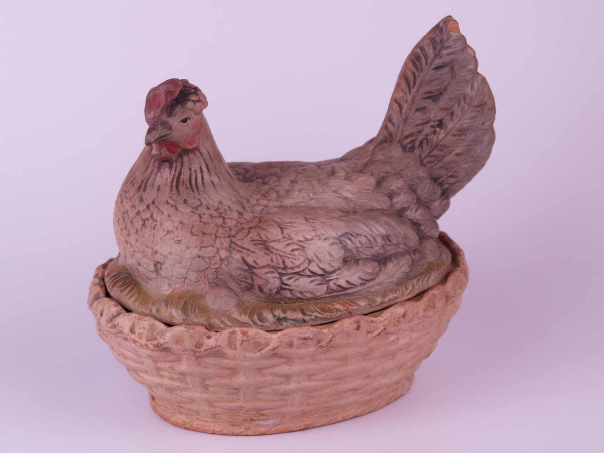 Kleine Deckelterrine - in Form einer Henne auf ihrem Korbnest,Keramik farbig staffiert,Glasur an