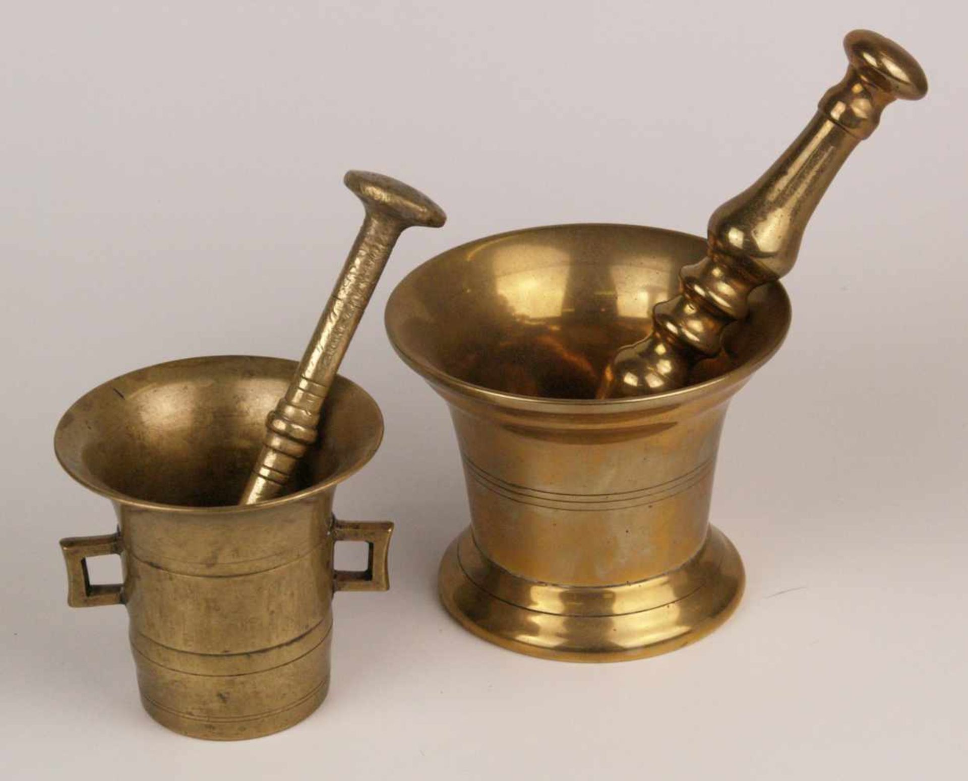 Zwei Mörser mit Pistill- Messing, 1x mit 2 Henkeln, H.ca.10cm, Pistill L.ca.17,5cm; 1x auf rundem