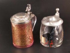 Zwei Glaskrüge - 1 roséfarbenes Glas klar überfangen mit goldenem Rankenwerk-Dekor, Metalldeckel mit