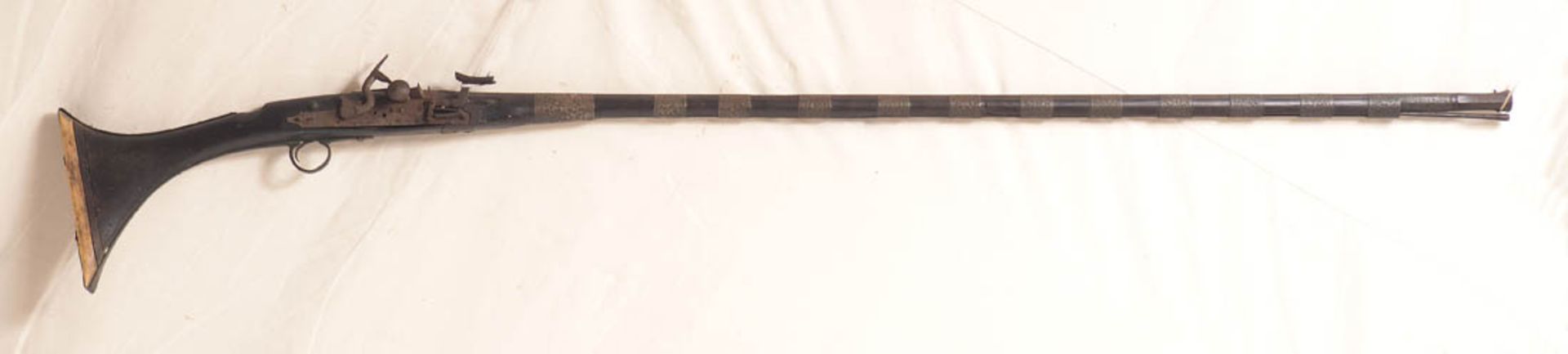 Flinte, arabisch Lauf mit reliefierten Metallbeschlägen, Schaft mit Beinabschluss. L.160cm.