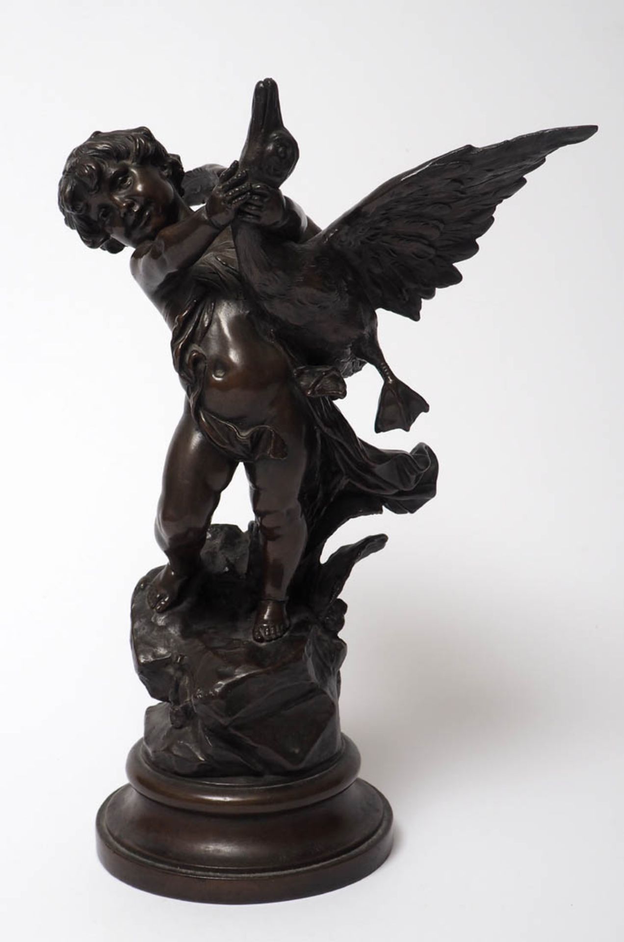 Figurine, 19.Jhdt. Auf profilierter, runder Plinthe Felssockel, darauf Putto, eine Gans am Hals