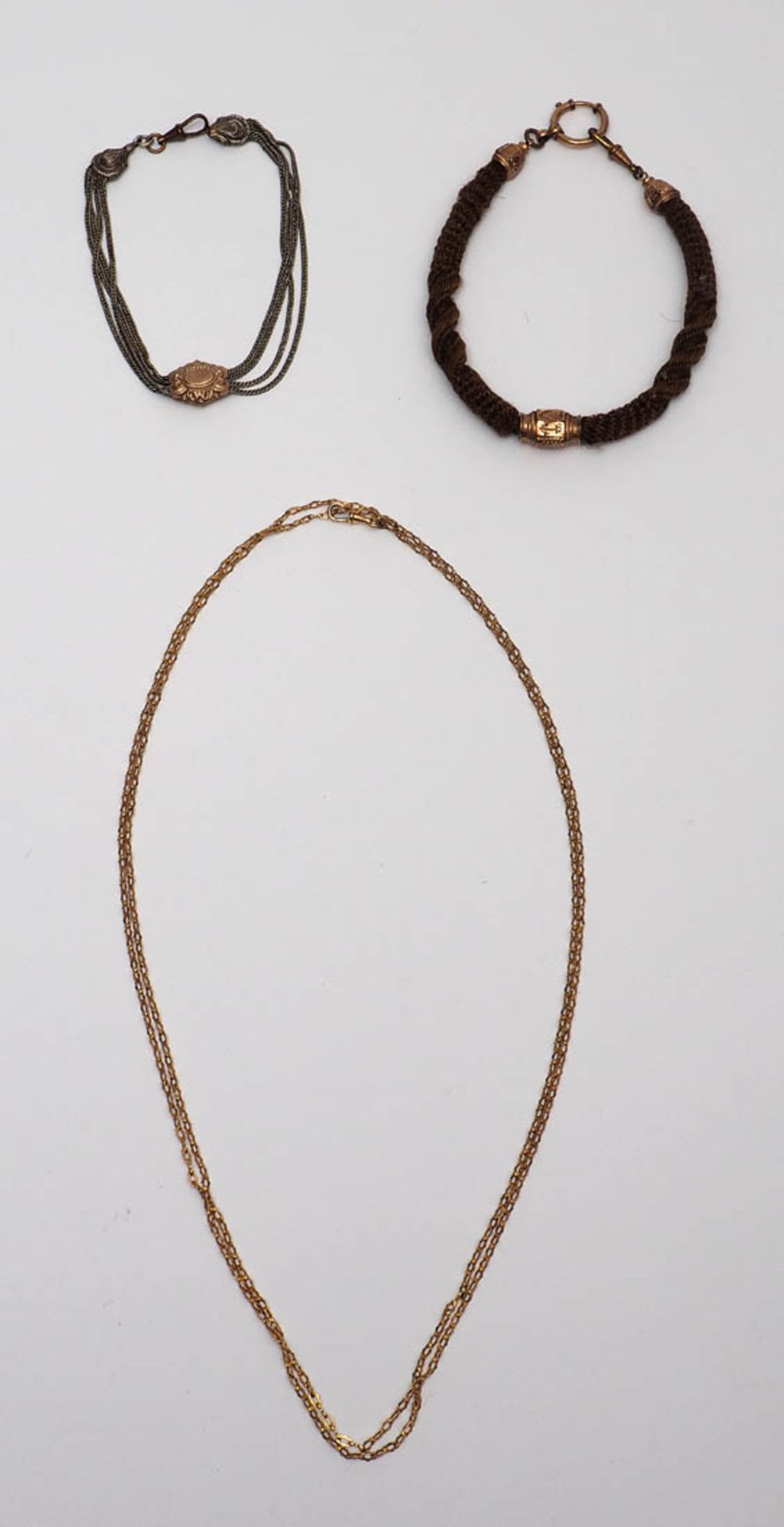 Drei Uhrenketten, 19.Jhdt. Eine aus geflochtenem Haar mit feuervergoldeten Schiebern, eine aus