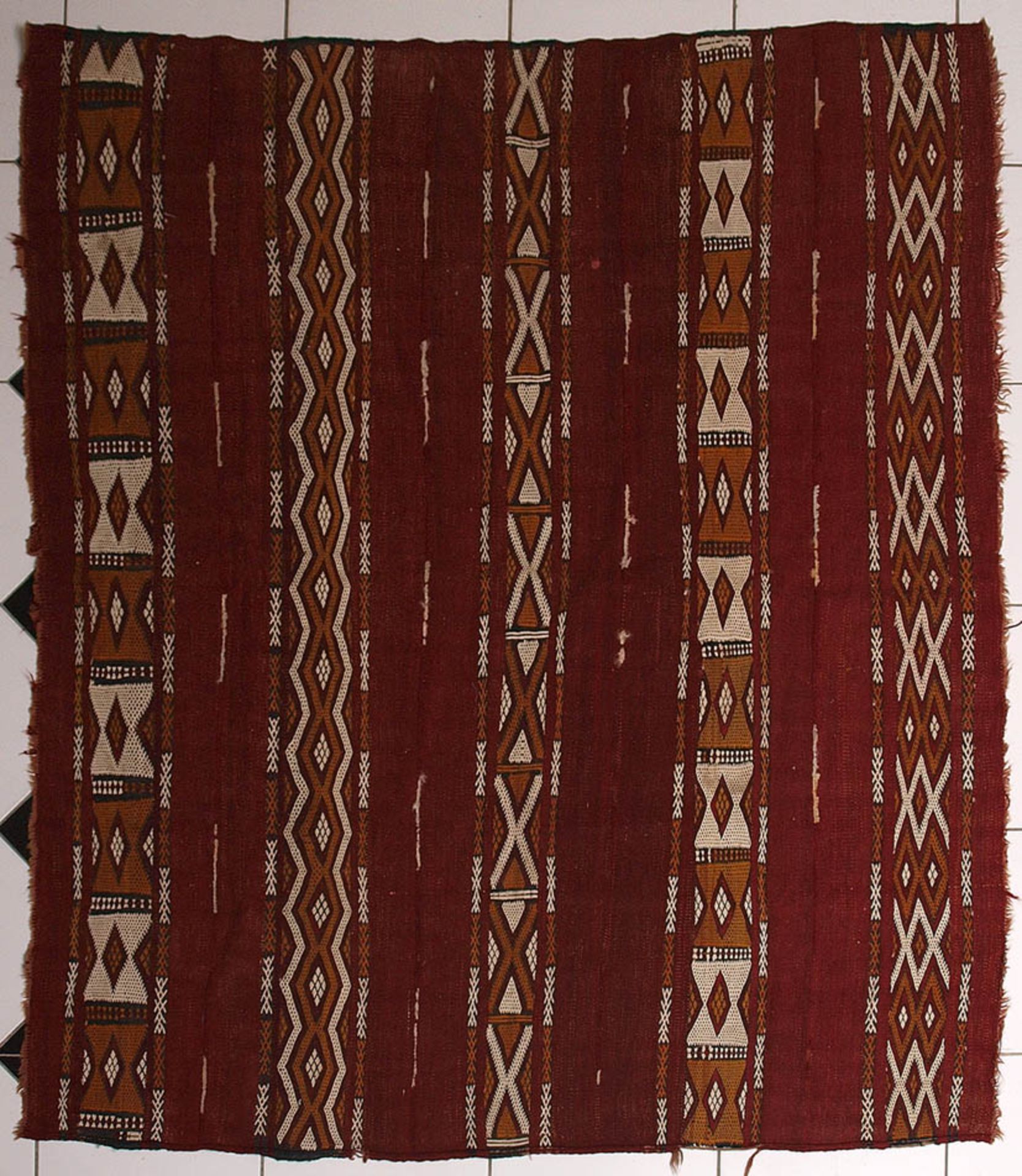 Kelim Rotgrundig, mit zweifarbigen Zacken- und Rautenbändern. 145x167cm.
