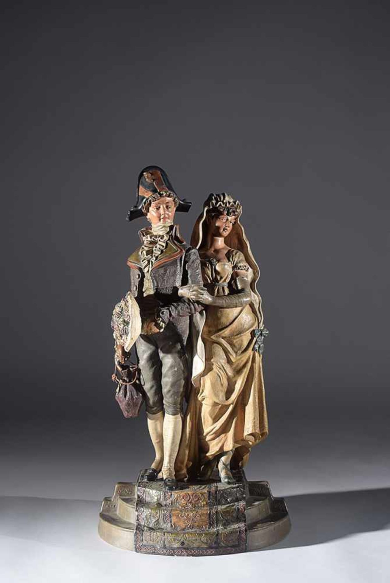 A polychrome terracotta group of a gentleman and a lady, 59cm. high (the gentleman's head