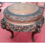 An eastern carved hardwood circular table with ornate floral design