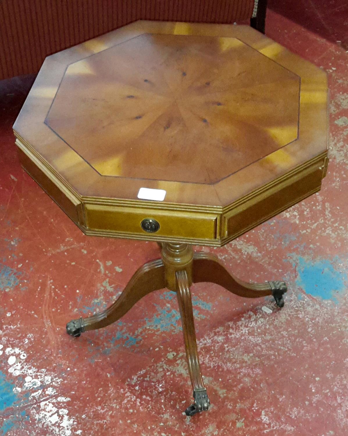 Octagonal top side table on single pedestal support on claw castor feet