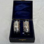 A pair of Birmingham silver napkin rings in their fitted box, maker Spurrier & Co, dated 1900