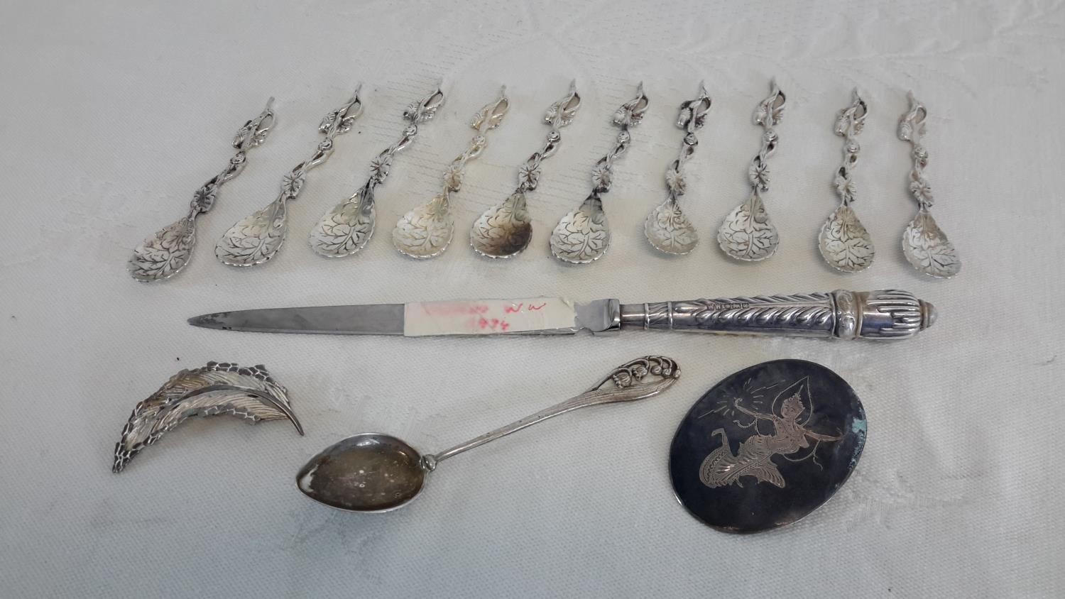 A collection of 800 grade and continental silver spoons, 925 leaf brooch, English silver handled