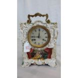 Henry Marc Paris clock in its gilted porcelain casing, has a hand painted couple scene, green & gilt