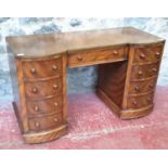 A 20th century knee hole desk with 4 drawers fitted on either side with a centre drawer