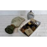 A collection of military badges, patches, gas mask & bottle