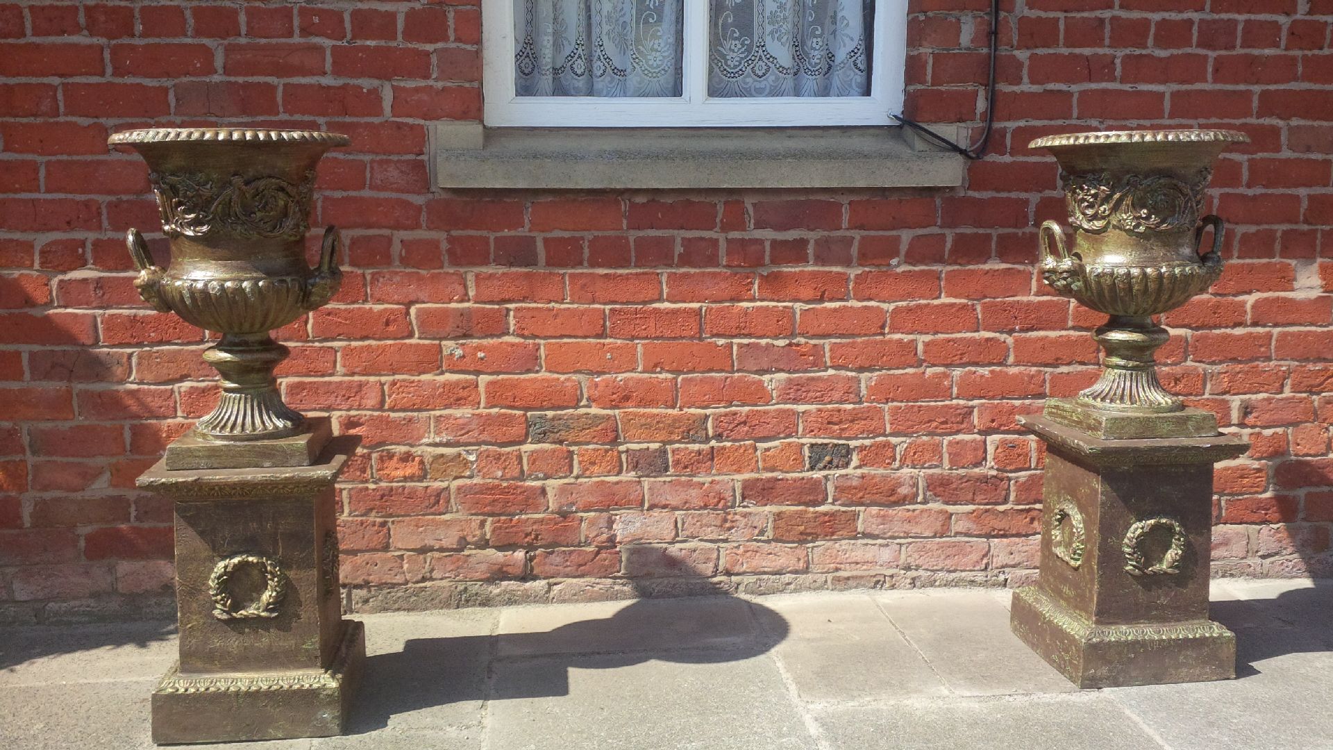 PAIR CAST IRON URNS ON PLINTH