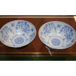 A pair of Chinese blue and white bowls, painted to the centre with four dancing figures, the