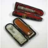 An amber cheroot holder with 9ct gold rim and a silver cheroot holder, both cased, (2)