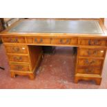 A yew wood pedestal desk with writing surface and nine drawers 77cm high, 137cm wide