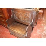 A 20th Century carved oak monks bench 92cm wide