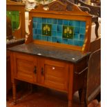 An Edwardian tile back wash stand, with marble top, a cupboard on ring turned legs 133cm high,