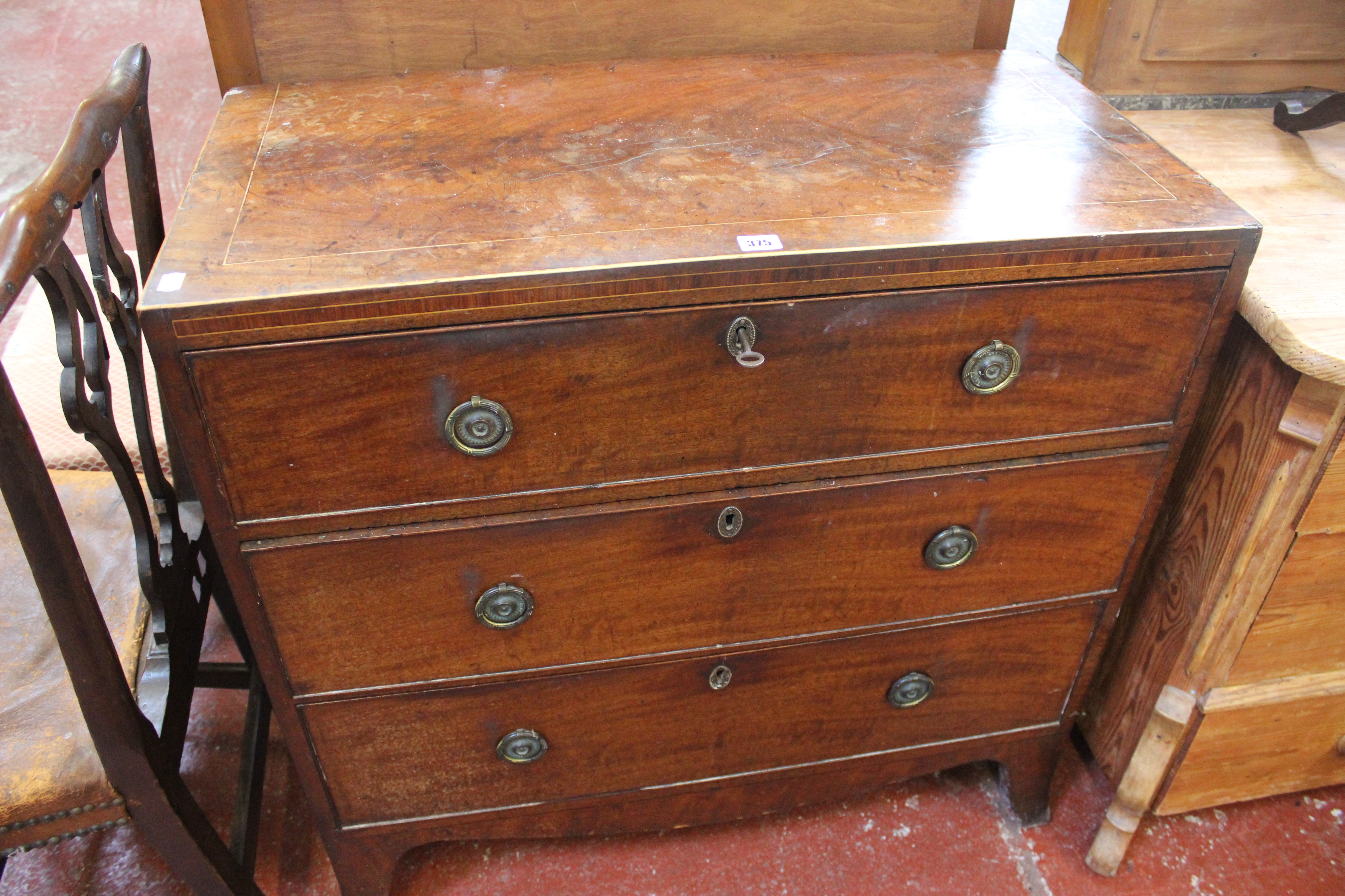 A Georgian mahogany and line inlaid chest with three long drawers on splayed legs 89cm wide