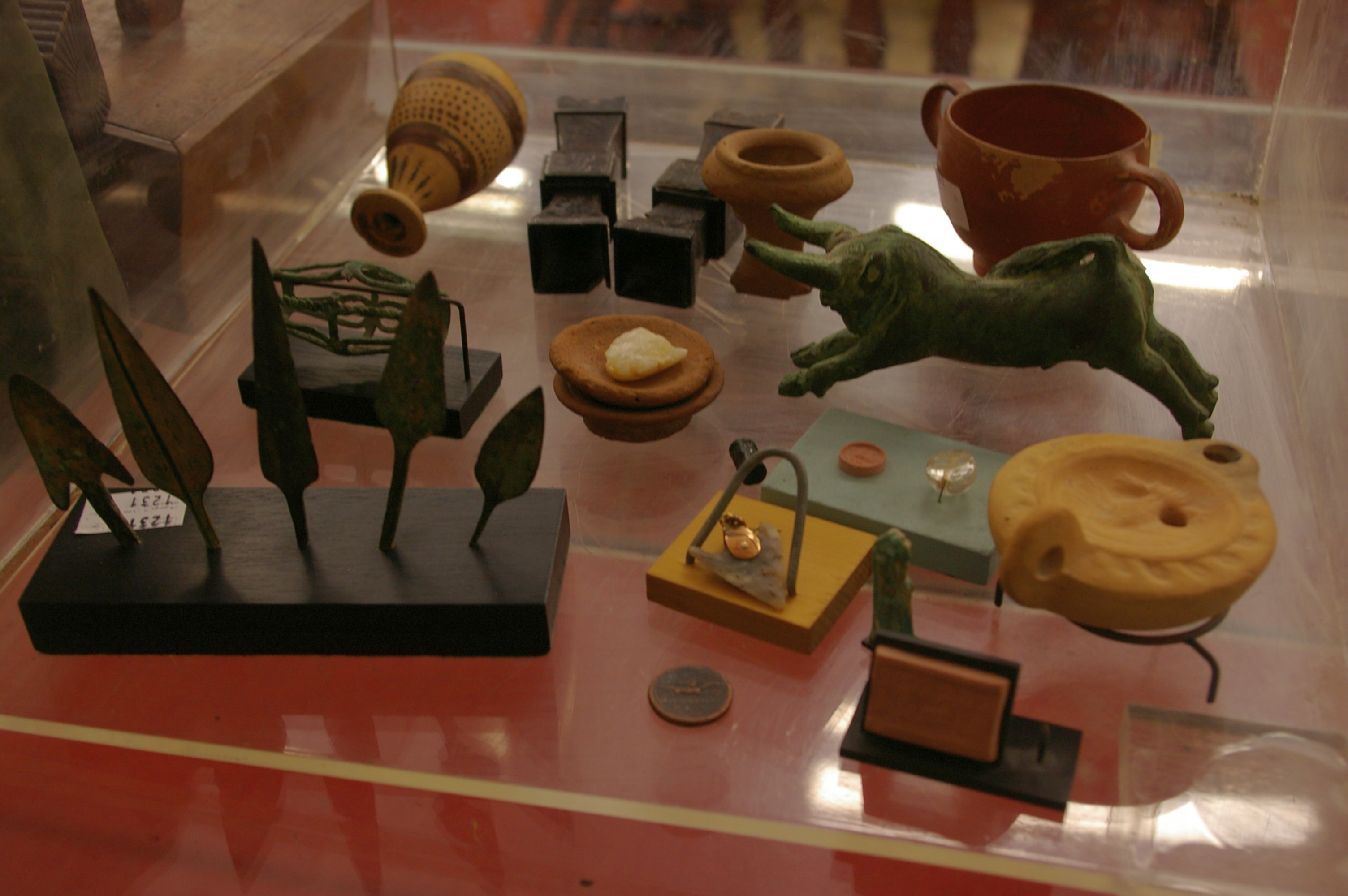 A mixed lot of miniature antiquities to include vases/urns, pendant, spear heads etc