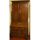 A George III mahogany bureau bookcase with a dentil moulded cornice and panelled cupboard above