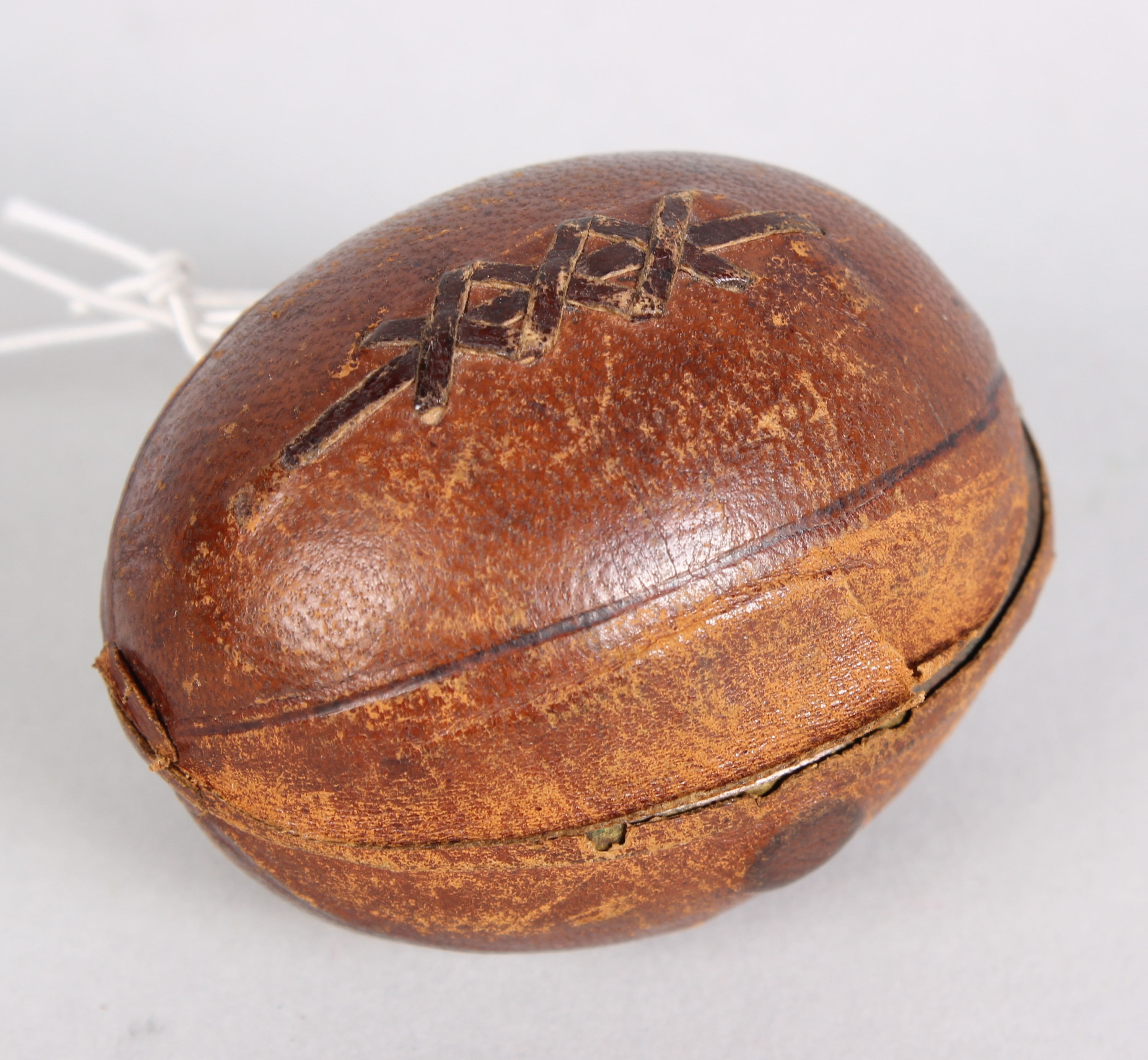 A Victorian novelty travelling inkwell, shaped as an American football covered in dark tan