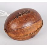 A Victorian novelty travelling inkwell, shaped as an American football covered in dark tan