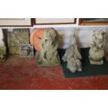 A group of garden ornament gargoyles, clock and stone relief panel