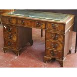 A mahogany and faux leather inset pedestal desk with nine short drawers 122cm wide