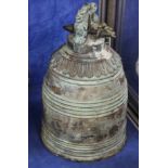 A Chinese bronze bell moulded with dragon faces, 35cm high,