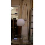 An Arc style lamp with translucent globe shade