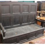 A 19th Century oak panelled settle 149cm high, 182cm wide