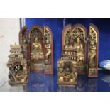 A pair of Sino Tibetan triptych wooden shrines with a gilt Buddha to the centre flanked by gilt