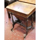 A Victorian walnut work table with hinged lid, work basket on turned legs joined by central