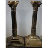 Silver; A pair of Corinthian Column Candlesticks with a square stepped base, D J Silver London 1964.