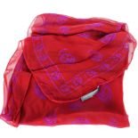 An Alexander McQueen skull-print silk scarf, red background with mauve skulls