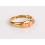 An 18ct gold and coral three stone ring, 4.3g in total